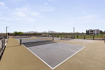 A tennis court with a net and two courtside buildings.